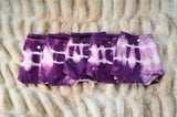 Five pairs side by side, each hand-dyed differently, running from deep aubergine to pale orchid